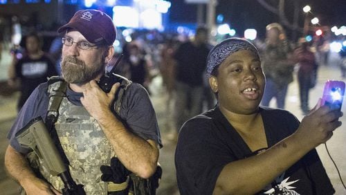 FERGUSON, MO - AUGUST 10: A demonstrator, marking the one-year anniversary of the shooting of Michael Brown, confronts an Oath Keeper during a protest along West Florrisant Street on August 10, 2015 in Ferguson, Missouri. Mare than 100 people were arrested today during protests in Ferguson and the St. Louis area. Brown was shot and killed by a Ferguson police officer on August 9, 2014. His death sparked months of sometimes violent protests in Ferguson and drew nationwide focus on police treatment of black offenders. (Photo by Scott Olson/Getty Images)