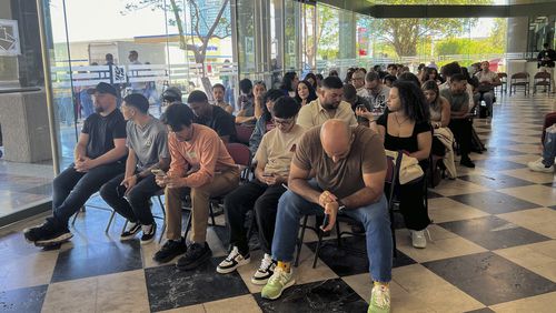 People wait at the Puerto Rico State Elections Commission in San Juan, Puerto Rico, Tuesday, Sept. 17, 2024. The voter registration deadline ends Sept. 21. (AP Photo/Danica Coto)