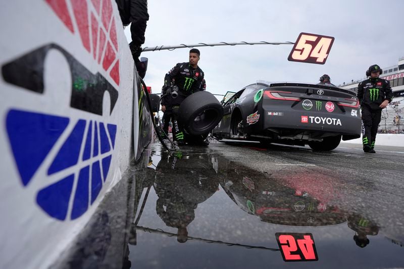 Pit crew for Ty Gibbs (54) work on the car in pit lane during a rain delay in a NASCAR Cup Series race, Sunday, June 23, 2024, at New Hampshire Motor Speedway in Loudon, N.H. (AP Photo/Steven Senne)
