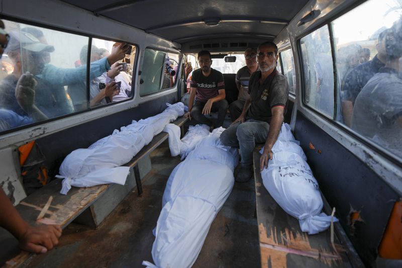 Mourners transport the bodies of their relatives killed in the Israeli bombardment of the Gaza Strip during their funeral in Deir al-Balah, Gaza, Monday, Sept. 23, 2024. (AP Photo/Abdel Kareem Hana)