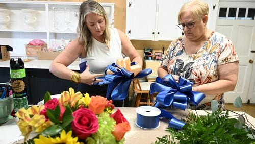 Ann's Flower and Gift Shop manager Paige Stinchcomb (left) and her mother Sherry Miller, the store's owner, make bows to support the families of victims who were killed at Apalachee High School.