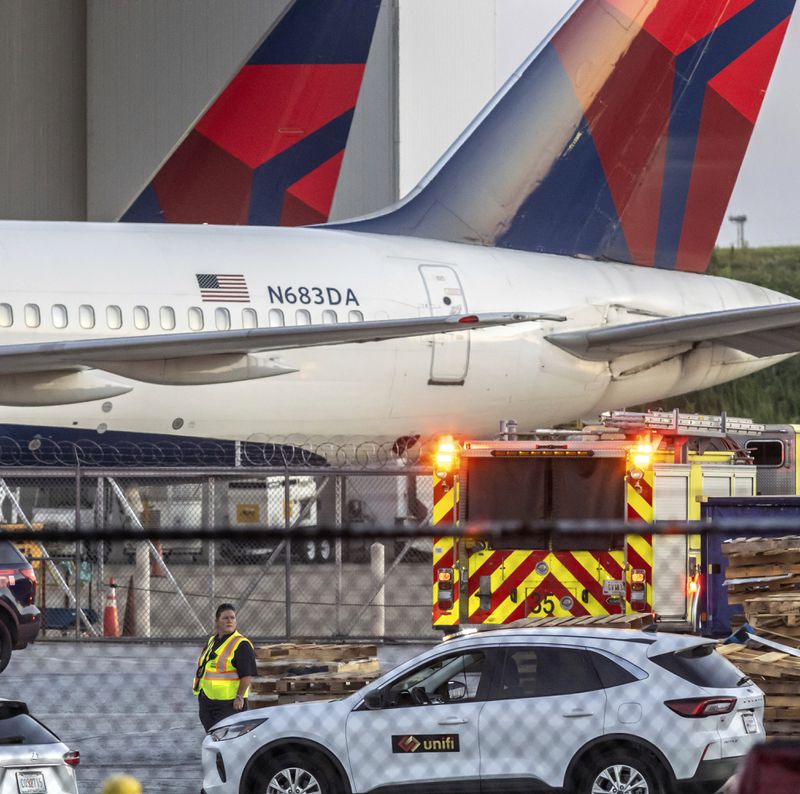 Multiple Atlanta Fire Rescue Department units and police park outside a Delta Maintenance facility near Hartsfield-Jackson International Airport early Tuesday, Aug. 27, 2024 in Atlanta. (John Spink/Atlanta Journal-Constitution via AP)