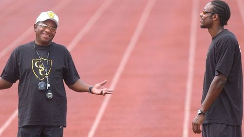 AJC file photo of legendary high school track and field coach Napoleon Cobb with working star pupil Angelo Taylor, his former athlete at Southwest DeKalb, while preparing Taylor for the Olympics.