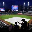 Fans receive word via the video wall that the game between the Atlanta Braves and Cincinnati Reds has been postponed due to weather at Truist Park on Tuesday, July 23, 2024, in Atlanta. (Todd Kirkland/Getty Images/TNS)