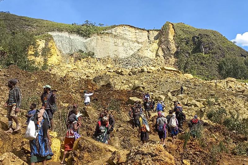 In this photo provided by the UNDP Papua New Guinea, villagers search through a landslide in Yambali village in the Highlands of Papua New Guinea, Sunday, May 26, 2024. The International Organization for Migration feared Sunday the death toll from a massive landslide is much worse than what authorities initially estimated. (Kafuri Yaro/UNDP Papua New Guinea via AP)