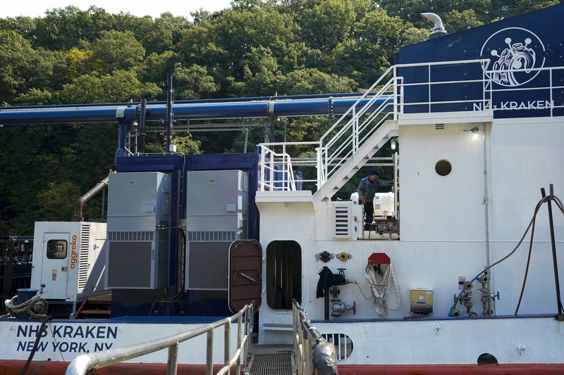 A worker walks on the NH3 Kraken, a tugboat powered by ammonia, Friday, Sept. 13, 2024, in Kingston, N.Y. (AP Photo/Alyssa Goodman)