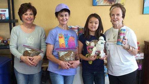 Volunteers Sandy Allen (from left), Ann Clutter, Natalya Sutaro and her grandmother Joyce Ahmad, the founder of People and Paws, meet at the charity’s expanded space to bag food. CONTRIBUTED