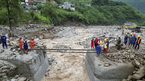 In this image made from video released by Xinhua News Agency, rescue workers set up a temporary crossing in the aftermath of floods in Xinhua Village of Hanyuan County, Ya'an City, southwest China's Sichuan Province, July 20, 2024. (Ya'an Integrated Media Center Handout/Xinhua via AP)