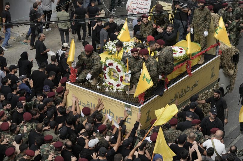 Hezbollah supporters march behind the hearse carrying the coffins of Hezbollah commander Ibrahim Akil and militant Mahmoud Hamad during their funeral procession in Beirut's southern suburb, Sunday, Sept. 22, 2024. (AP Photo/Bilal Hussein)