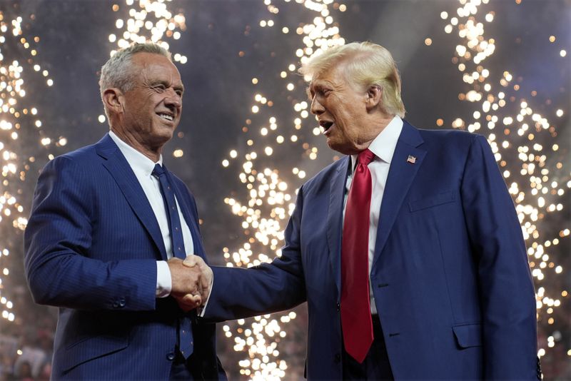 Republican presidential nominee former President Donald Trump shakes hands with Independent presidential candidate Robert F. Kennedy Jr. at a campaign rally at the Desert Diamond Arena, Friday, Aug. 23, 2024, in Glendale, Ariz. (AP Photo/Evan Vucci)