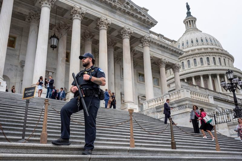 A U.S. Capitol Police officer stands watch as lawmakers leave the House of Representatives on Wednesday after voting on an interim spending bill to avoid a government shutdown.