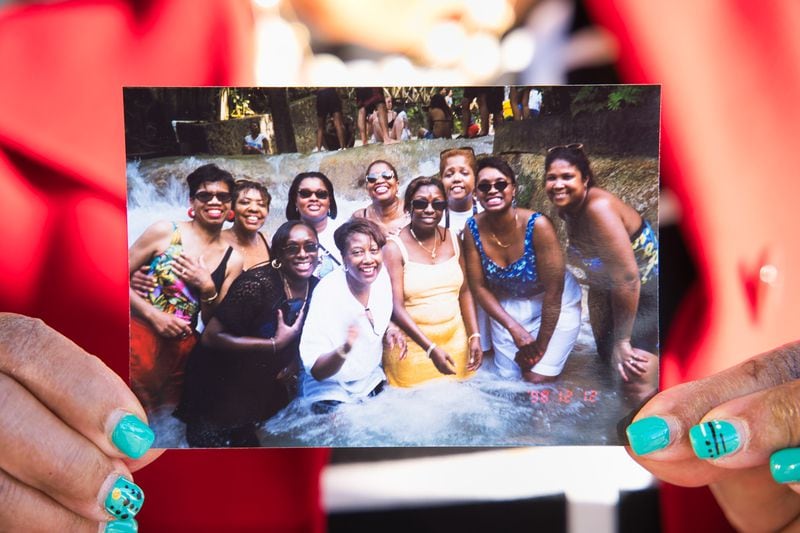 Joyce Wynn Dawkins holds a photo showing some of the Sugar Hill women. The group has been on adventures around the world. David Carter for The Washington Post