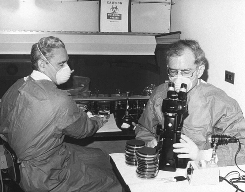 This 1978 photo shows Centers for Disease Control laboratorian George Gorman (left) along with Dr. Jim Feeley while they were examining culture plates, i.e., Petri dishes, upon which the first environmental isolates of Legionella pneumophils had been grown. -- Text by the CDC