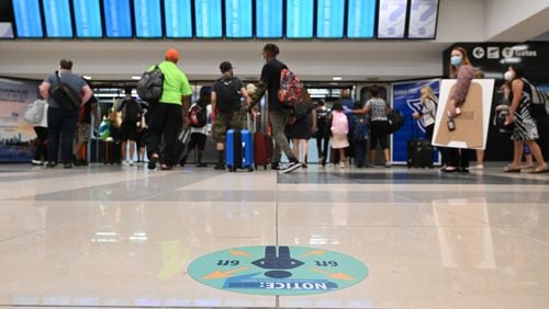 July 22, 2020 Atlanta - Social distancing signs are  displayed as travelers wait for a train on Concourse A at Hartsfield-Jackson International Airport on Wednesday, July 22, 2020. (Hyosub Shin / Hyosub.Shin@ajc.com)