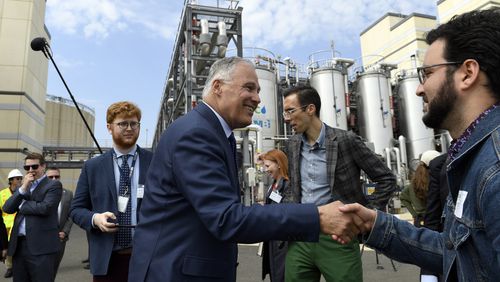 FILE - Democratic Presidential candidate Washington Gov. Jay Inslee, center, greets people as he tours the Blue Plains Advanced Wastewater Treatment Plant in Washington, Thursday, May 16, 2019, during an event where he unveiled part of his plan to defeat climate change. (AP Photo/Susan Walsh, File)