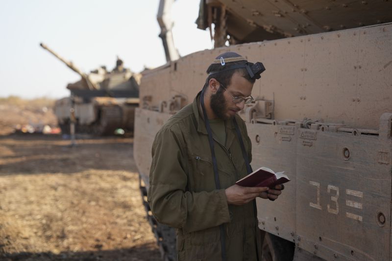 An Israeli soldier prays at a staging area in northern Israel, Sunday, Oct. 6, 2024. (AP Photo/Baz Ratner)