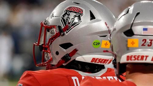 New Mexico quarterback Devon Dampier (4) wears a green dot on his helmet which allows him communication with a coach during the first half of an NCAA college football game against Arizona, Saturday, Aug 31, 2024, in Tucson, Ariz. (AP Photo/Darryl Webb)