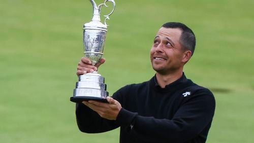 Xander Schauffele of the United States holds the Claret Jug trophy aloft after winning the British Open Golf Championships at Royal Troon golf club in Troon, Scotland, Sunday, July 21, 2024. (AP Photo/Scott Heppell)