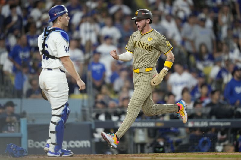 San Diego Padres' Jackson Merrill, right, celebrates as he scores as Los Angeles Dodgers catcher Will Smith, left, reacts during the third inning in Game 1 of baseball's NL Division Series, Saturday, Oct. 5, 2024, in Los Angeles. (AP Photo/Mark J. Terrill)