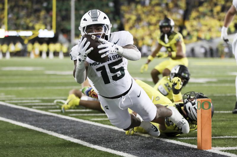 Michigan State running back Kay'Ron Lynch-Adams, left, is tackled out of bounds by Oregon linebacker Teitum Tuioti, right, during the second half of an NCAA college football game, Friday, Oct. 4, 2024, in Eugene, Ore. Oregon won 31-10. (AP Photo/Amanda Loman)