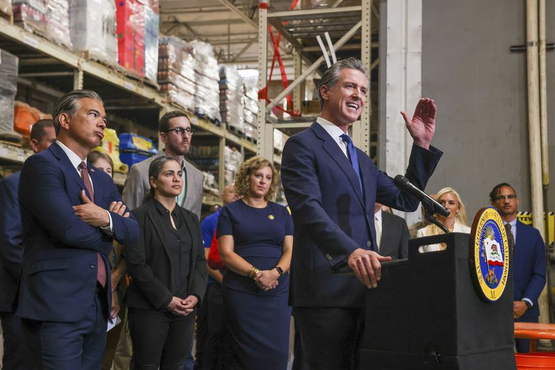 FILE - California Gov. Gavin Newsom speaks as Attorney General Bob Bonta, second from left, looks on after signing a bipartisan package of bills to combat retail crime during a press conference with state and local officials at Home Depot in San Jose, Calif., on Friday, Aug. 16, 2024. (Ray Chavez/Bay Area News Group via AP, File)