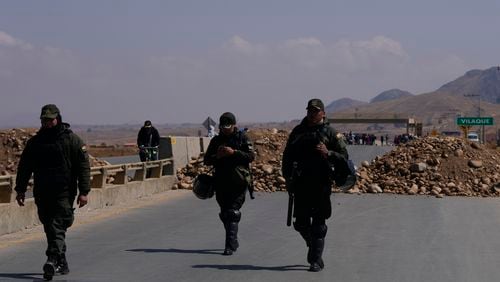 Police patrol at a roadblock in Vilaque on the outskirts of El Alto, Bolivia, Monday, Sept. 16, 2024. The roadblock was placed by protesters demanding the resignation of Bolivian President Luis Arce for his management of the economy. (AP Photo/Juan Karita)