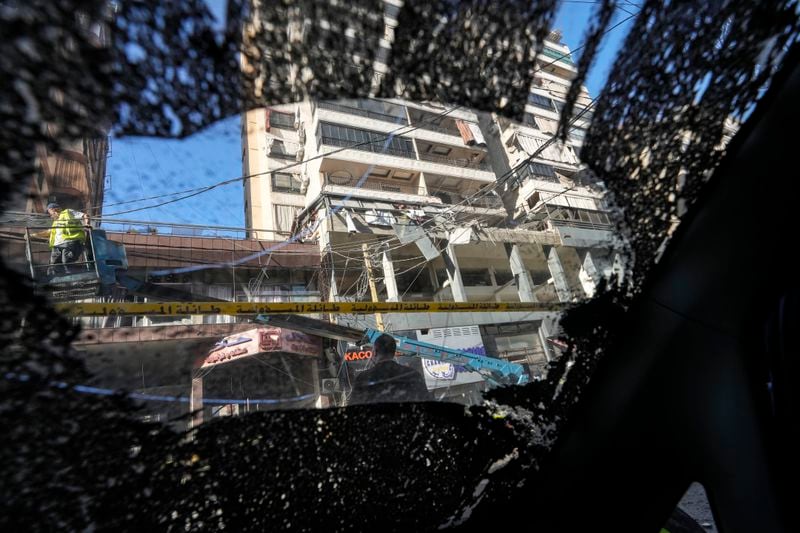 The damaged building at the site of an Israeli airstrike, seen from the shattered window of a car, in Beirut's southern suburb, Thursday, Sept. 26, 2024. (AP Photo/Hassan Ammar)