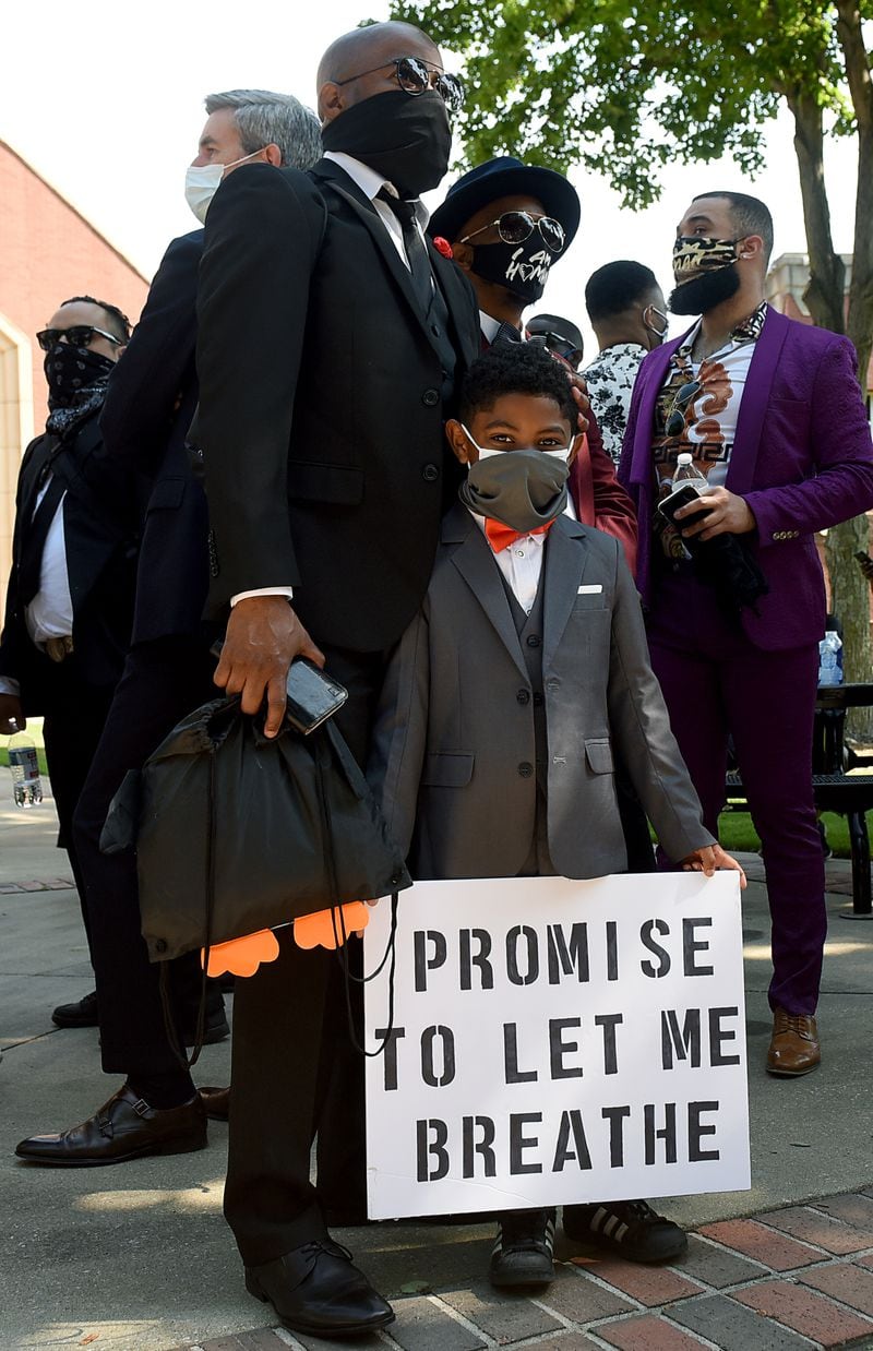 Young Roman Thomas, 7, stands with his father, Ro Thomas. More than 1,000 people gathered for an Atlanta Community March in honor of George Floyd’s funeral on June 4, 2020. It started at the Martin Luther King Jr. National Historical Park in Atlanta. The people were dressed in their “Sunday best” as an “artistic and peaceful protest/march.” RYON HORNE / RHORNE@AJC.COM