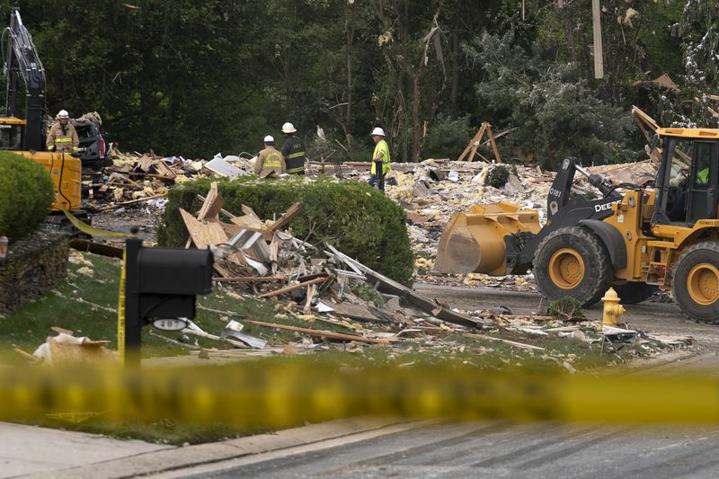 Crew workers remove debris after a house exploded in Bel Air, Md. neighborhood, Sunday, Aug. 11, 2024. (AP Photo/Jose Luis Magana)