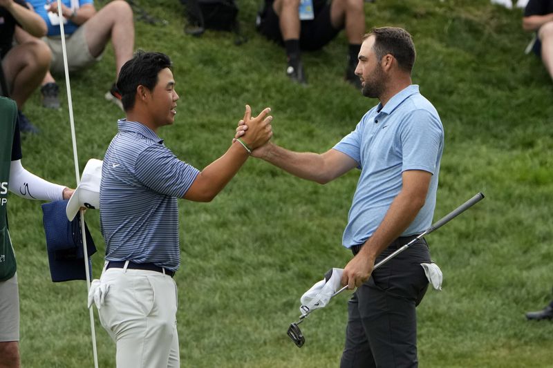 Scottie Scheffler, right, shakes hands with Tom Kim, of South Korea, after winning the Travelers Championship golf tournament at TPC River Highlands, Sunday, June 23, 2024, in Cromwell, Conn. (AP Photo/Seth Wenig)