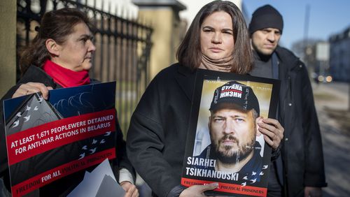 FILE - Belarusian opposition leader Sviatlana Tsikhanouskaya, center, holds a portrait of her jailed husband, Siarhei Tsikhanouski, at a protest outside the Belarus Embassy, in Vilnius, Lithuania, on March 8, 2024, demanding freedom for political prisoners. (AP Photo/Mindaugas Kulbis, File)