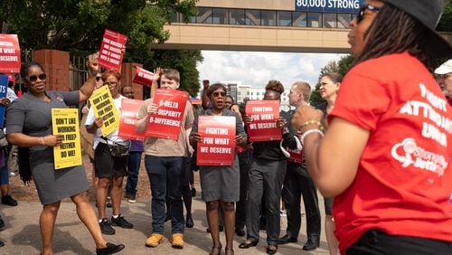 AFA international Vice President Keturah Johnson (right) speaks to protesters. Endeavor Air flight attendants demonstrate outside of Delta headquarters in Atlanta. Demonstrators held signs and yelled chants demanding an end to tiered treatment. Thursday, Oct. 3, 2024. (Ben Hendren for the Atlanta Journal-Constitution)