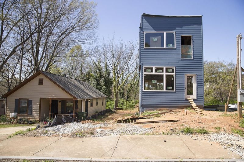 A newly developed house sits next to an older residence in the Summerhill community. 