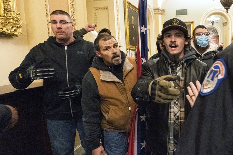 FILE - Michael Sparks, left, and Kevin Seefried, second from left, as they and other rioters loyal to President Donald Trump are confronted by U.S. Capitol Police officers outside the Senate Chamber inside the Capitol in Washington, Jan. 6, 2021. (AP Photo/Manuel Balce Ceneta, File)