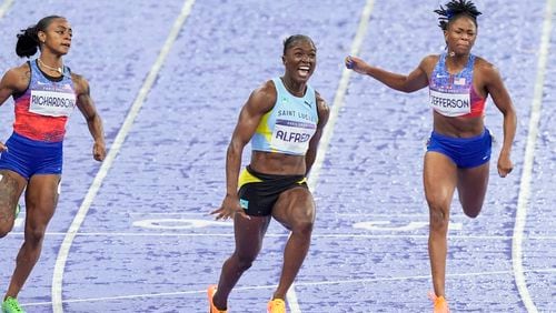 Julien Alfred, of Saint Lucia, crosses the finish line ahead of Sha'carri Richardson, of the United States, and Melissa Jefferson, of the United States, to win the women's 100 meters final at the 2024 Summer Olympics, Saturday, Aug. 3, 2024, in Saint-Denis, France. (AP Photo/Martin Meissner)