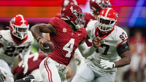 Alabama Crimson Tide quarterback Jalen Milroe (4) runs past Georgia Bulldogs defensive lineman Warren Brinson (97) during the second half of the SEC Championship football game at the Mercedes-Benz Stadium in Atlanta, on Saturday, December 2, 2023. (Jason Getz / Jason.Getz@ajc.com)