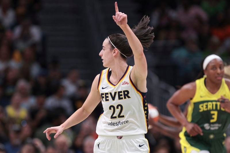 Indiana Fever guard Caitlin Clark (22) points downcourt as Seattle Storm forward Nneka Ogwumike (3) runs nearby during the first half of a WNBA basketball game Wednesday, May 22, 2024, in Seattle. (AP Photo/Jason Redmond)