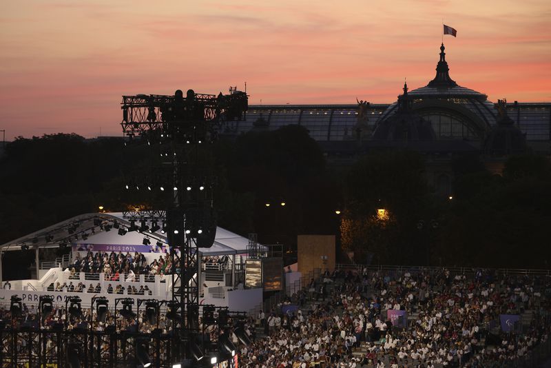 The crowd attends the Opening Ceremony for the 2024 Paralympics, Wednesday, Aug. 28, 2024, on the Concorde plaza, with the Grand Palais in background, in Paris, France. (AP Photo/Thomas Padilla)