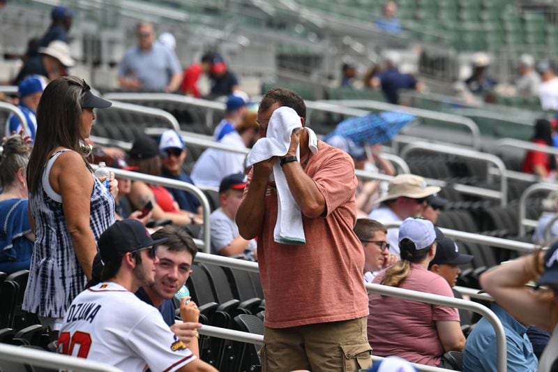 A baseball fan wipes his sweat as he waits for Atlanta Braves home game against the Arizona Diamondbacks at Truist Park on Thursday in Atlanta, where temperatures were expected to reach the upper 90s. (Hyosub Shin / Hyosub.Shin@ajc.com)