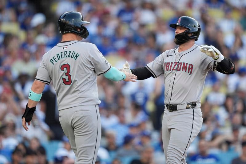 Arizona Diamondbacks' Christian Walker, right, celebrates after his two-run home run with designated hitter Joc Pederson, left, who also scored, during the third inning of a baseball game against the Los Angeles Dodgers, Thursday, July 4, 2024, in Los Angeles. (AP Photo/Ryan Sun)