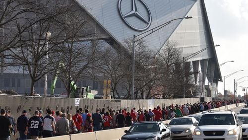 December 2, 2017 Atlanta - Fans walk to Mercedes-Benz Stadium before Southeastern Conference championship NCAA college football game between Georgia and Auburn on Saturday, December 2, 2017. HYOSUB SHIN / HSHIN@AJC.COM