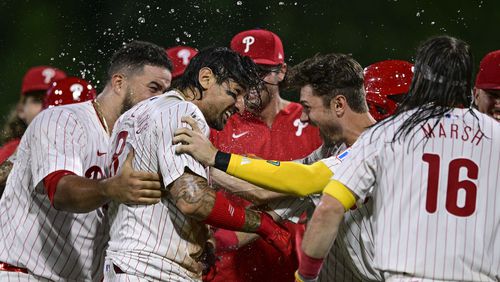 Philadelphia Phillies' Nick Castellanos, center left, celebrates with teammates after hitting a walk off single against Atlanta Braves' Grant Holmes during the 11th inning of a baseball game, Sunday, Sept. 1, 2024, in Philadelphia. (AP Photo/Derik Hamilton)