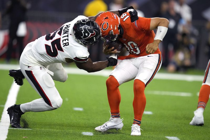 Chicago Bears quarterback Caleb Williams, right, is grabbed by Houston Texans defensive end Danielle Hunter (55) during the second half of an NFL football game Sunday, Sept. 15, 2024, in Houston. (AP Photo/Eric Christian Smith)