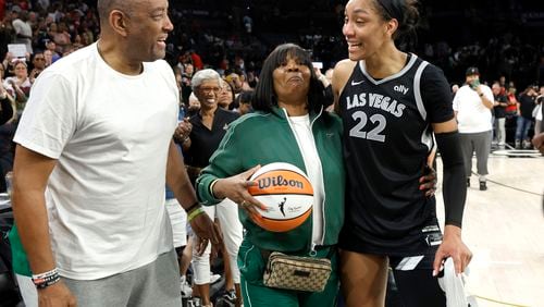 Las Vegas Aces center A'ja Wilson (22) celebrates with her parents Roscoe and Eva Wilson after an WNBA basketball game against the Connecticut Sun, Sunday, Sept. 15, 2024, in Las Vegas. (Steve Marcus/Las Vegas Sun via AP)