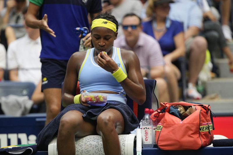 Coco Gauff, of the United States, eats during a break between games against Emma Navarro, of the United States, during the fourth round of the U.S. Open tennis championships, Sunday, Sept. 1, in New York. 2024. (AP Photo/Pamela Smith)