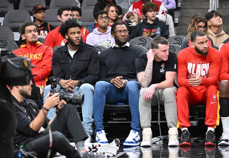 New Hawks players (from left) Saddiq Bey, Bruno Fernando and Garrison Mathews sit on the bench during the first half. (Hyosub Shin / Hyosub.Shin@ajc.com)