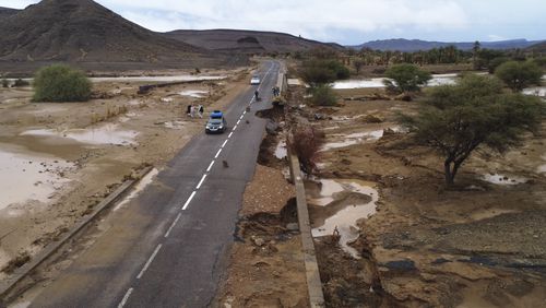 Cars drive through a road that was damaged by floods caused by heavy rainfall in Tazarine, Zagora, southern Morocco, Sunday, Sept. 8, 2024. Moroccan authorities say exceptional weather has killed at least 11 people and destroyed homes in southern Morocco. (AP Photo)