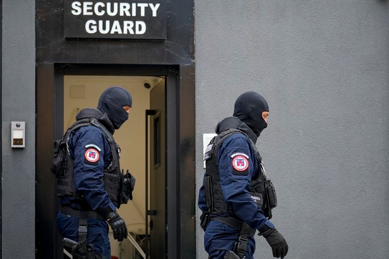 Gendarmes wearing balaclavas exit the residence of internet influencer Andrew Tate during an early morning police search raid, on the outskirts of Bucharest, Romania, Wednesday, Aug. 21, 2024. (AP Photo/ Vadim Ghirda)