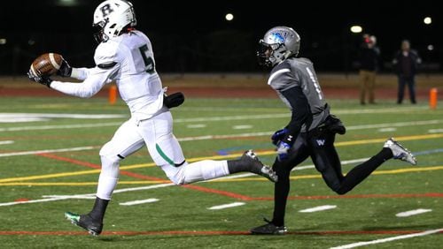 Roswell High School wide receiver Jayden Comma (5) completes a catch while being pursued by Westlake High School's Tre Person (1) during the second half of a semi-final high school football game, Friday, Dec. 2, 2016, in Atlanta. Roswell defeated Westlake 28-0. Branden Camp/Special