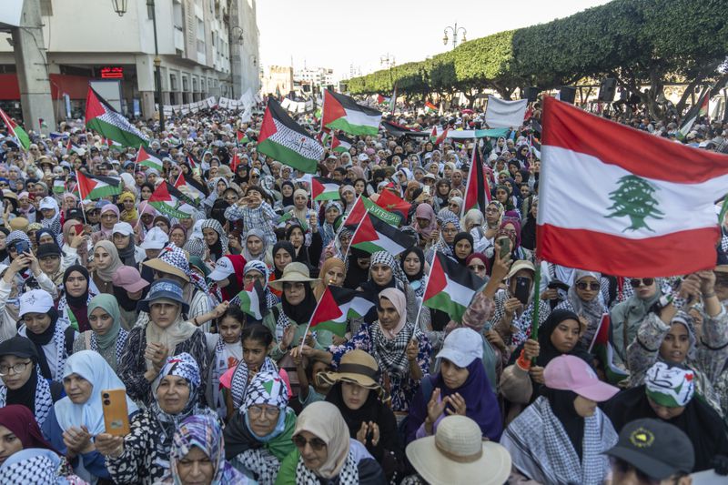 Women wave flags and chant slogans in support of Gaza and Lebanon during a protest in Rabat, Morocco, Sunday, Oct. 6, 2024 (AP Photo/Mosa'ab Elshamy)